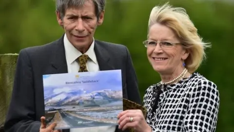 PA Media The Earl of Lonsdale with his wife Lady Lonsdale in 2014 with the Blencathra sale brochure