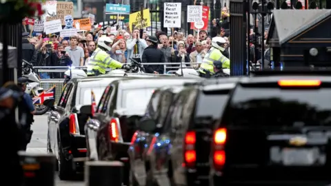 AFP Demonstrators at Downing Street watch motorcade leave