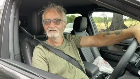 Andrew Turner/BBC Keith Gant behind the wheel of a Land Rover