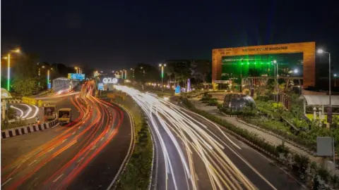 Reuters Traffic moves past a G20 logo installed in front of the main venue of the summit in New Delhi, India, August 25, 2023.
