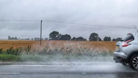 Wilburwalker/Weather Watchers A car driving through the rain at Ramsey Saint Mary's, Cambridgeshire