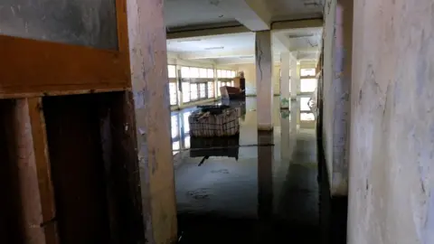 BBC Picture of a flooded ground floor of the abandoned building.