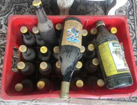 Kalkidan Yibeltal/BBC Bottles of beer, wine and olive oil in a crate