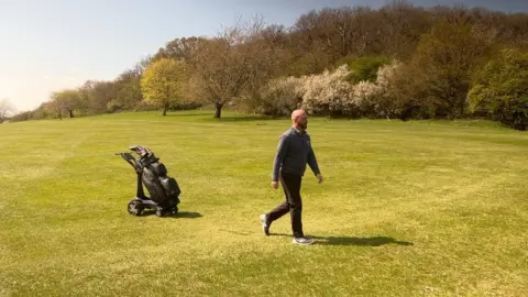 BBC Mark Stewart and a remote controlled golf trolley