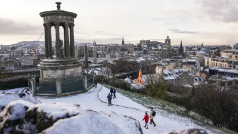 PA Media People are seen playing in the snow on Calton Hill on December 8, 2022 in Edinburgh, Scotland.