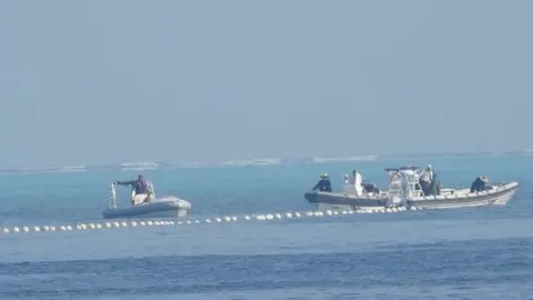 Philippine Coast Guard/Handout via Reuters Chinese coast guard boats close to the floating barrier are pictured near the Scarborough Shoal