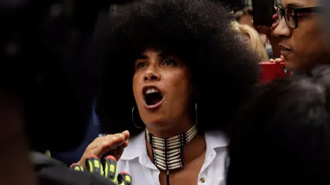 Lili Bernard is confronted by supporters of Bill Cosby outside the courthouse where his trial is held.