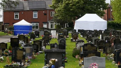 Police tents in a graveyard