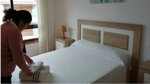 Reuters/Perla Requejo Airbnb host Perla Requejo folds towels in the property that she rents to holidaymakers on Airbnb in Sanxenxo, Spain December 7, 2020.