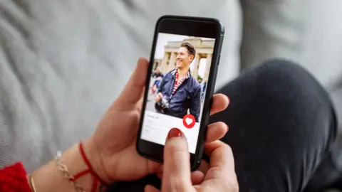 Getty Images A woman looks at a man on Tinder