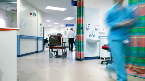 Science Photo Library A wheelchair sits in a hospital corridor