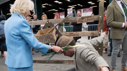 Getty Images The Duchess of Cornwall knights the "farmer"