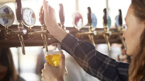 Getty Images Pub worker pouring beer