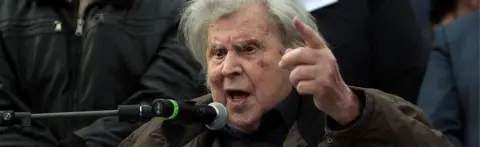 AFP Greek composer Mikis Theodorakis gives a speech during a demonstration to urge the government not to compromise in the festering name row with neighbouring Macedonia, at the Syntagma Square in Athens, on 4 February 2018