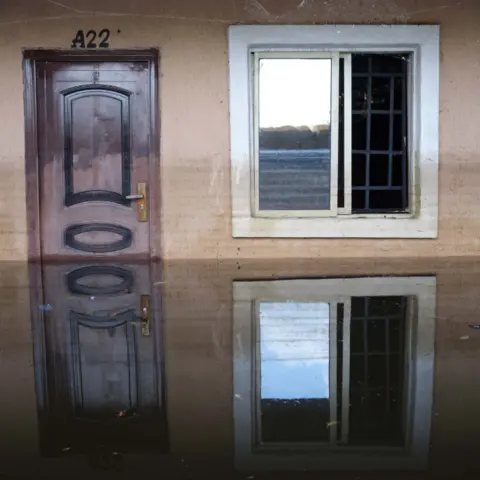 Gideon Mendel Floodwater outside a door at Dorca Executive Apartments (student accommodation) in Ogbia Municipality, Bayelsa State, Nigeria - November 2022