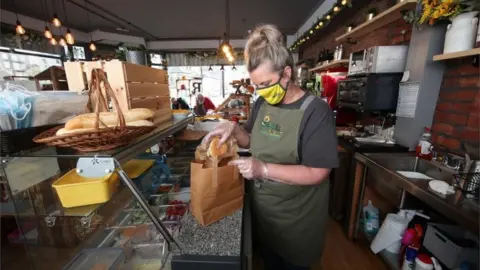 PA Media Ali Waterworth, co-founder of Ruddi"s Retreat in Huddersfield, preparing a food bag.