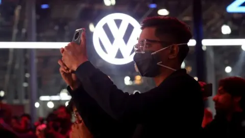 EPA A visitor wears a mask as a precautionary measure against Corona virus at the Volkswagen showcasing hall during the India Auto Expo 2020 in Greater Noida, India, 05 February 2020.