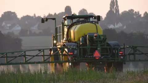 Getty Images A French farmer sprays glyphosate herbicide "Roundup 720" made by agrochemical giant Monsanto, in northwestern France, in a field of rye, peas, faba beans, triticals and Bird's-foot trefoil, on September 16, 2019.