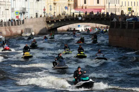 Sergei Konkov / TASS via Getty Images Jet skiers race along the Winter Canal in St Petersburg, Russia