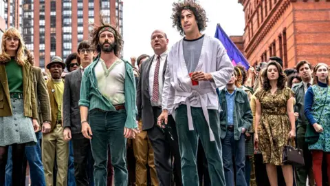 Netflix Jeremy Strong and Sacha Baron Cohen with other cast members of The Trial of the Chicago 7