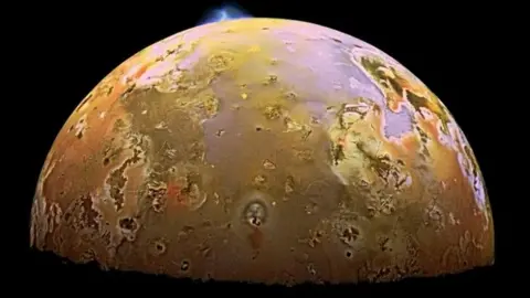 NASA/Science Photo Library A yellow moon with an erupting volcano