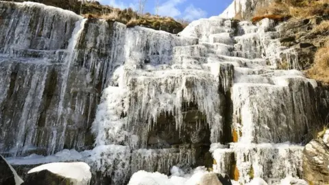 PA Icicles formed on a frozen waterfall near Pen y Fan mountain on Brecon Beacon National Park, Wales,