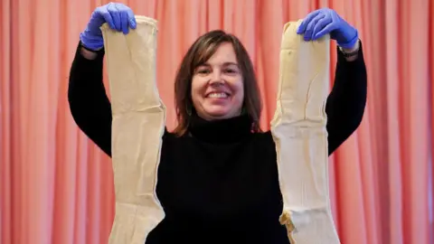 PA Media Senior Conservation Manager for Imaging Sarah Noble views 200-year-old samples of fine women’s knee length woollen stockings which were found in a parcel among a stash of 19th-century letters, when opened for the first time at the National Archives in Kew, London.