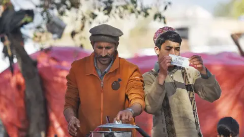 Getty Images Men cook tea at a roadside stall in Pakistan