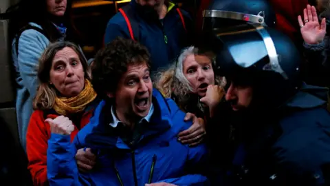 AFP Catalan pro-independence demonstrators protest against the visit of Spain's King Felipe VI at the Mobile World Congress (MWC) in front of Catalan regional police officers Mossos d'Esquadra on February 25, 2018, in Barcelona