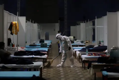 Getty Images A ward boy sweeping the floor of a ward