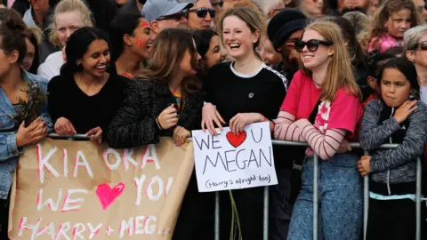 Reuters Signs held up for the arrival of the Duke and Duchess of Sussex