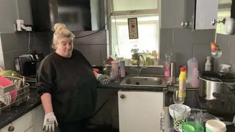 Carly Jeans standing in a kitchen