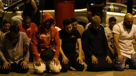 Getty Images Worshippers pray on the street after the attack