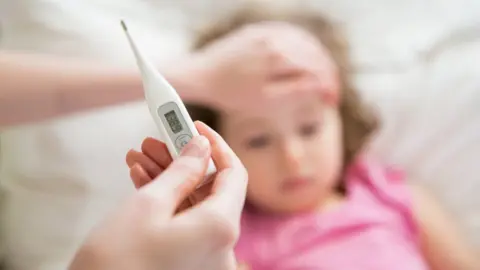 Getty Images Parent monitoring child's temperature