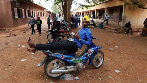 AFP A Malian man rests on a motorcycle at a polling station in Bamako, Mali - 29 July 2018