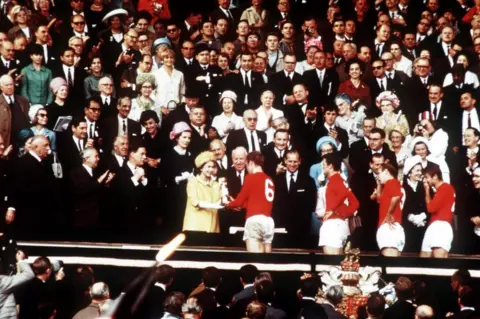 Mirrorpix / Getty Images England captain Bobby Moore holds the Jules Rimet Trophy, collected from the Queen, after leading his team to a 4-2 victory over West Germany in the World Cup Final that went to extra time at Wembley, London