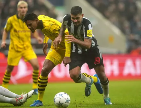 PA Media Borussia Dortmund's Sebastien Haller (left) and Newcastle United's Bruno Guimaraes battle for the ball during the UEFA Champions League Group F match at St. James' Park