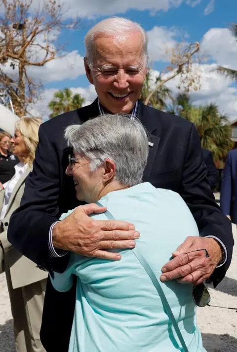 Evelyn Hockstein/Reuters US President Joe Biden hugs a woman