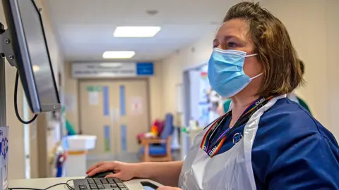 An NHS worker checks patient records on a computer at Nevill Hospital on March 08, 2021 in Abergavenny, Wales