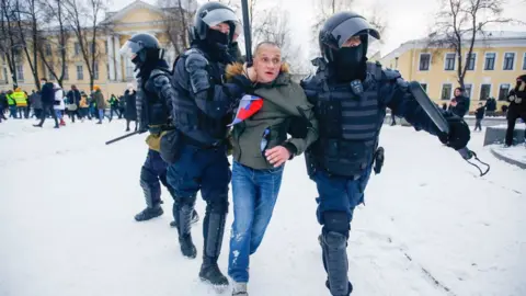 Getty Images Police officers detain a protester in St Petersburg