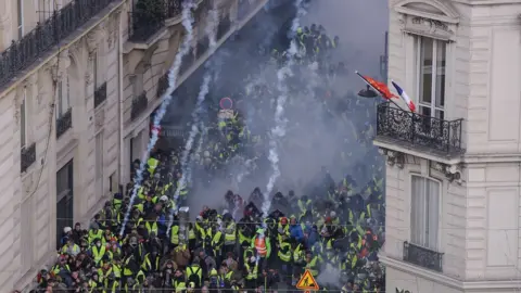 AFP Protesters flee as the police in Paris fire tear gas