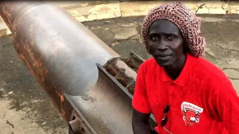 Massar Mbodj sitting on a cannon