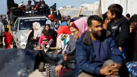 Reuters Palestinians flee the city of Khan Younis on pick-up trucks and horse-drawn carts amid intense fighting in the southern Gaza Strip (22 January 2024)