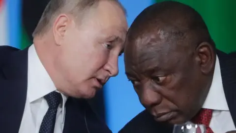 Getty Images Russia's President Vladimir Putin (L) and South Africa's President Cyril Ramaphosa attend the first plenary meeting of the Russia-Africa Summit at the Sirius Park of Science and Art