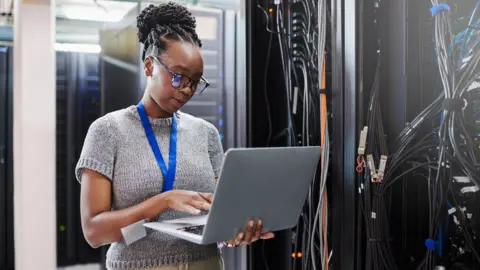 Getty Images A black woman working in a server room