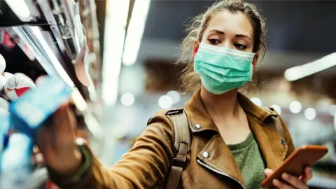 Getty Images Woman shopping in mask