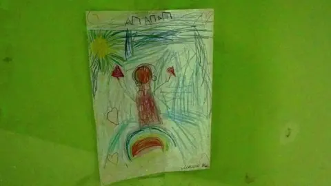 A child's drawing of a figure in headphones. There is a faint "Z" symbol in the corner