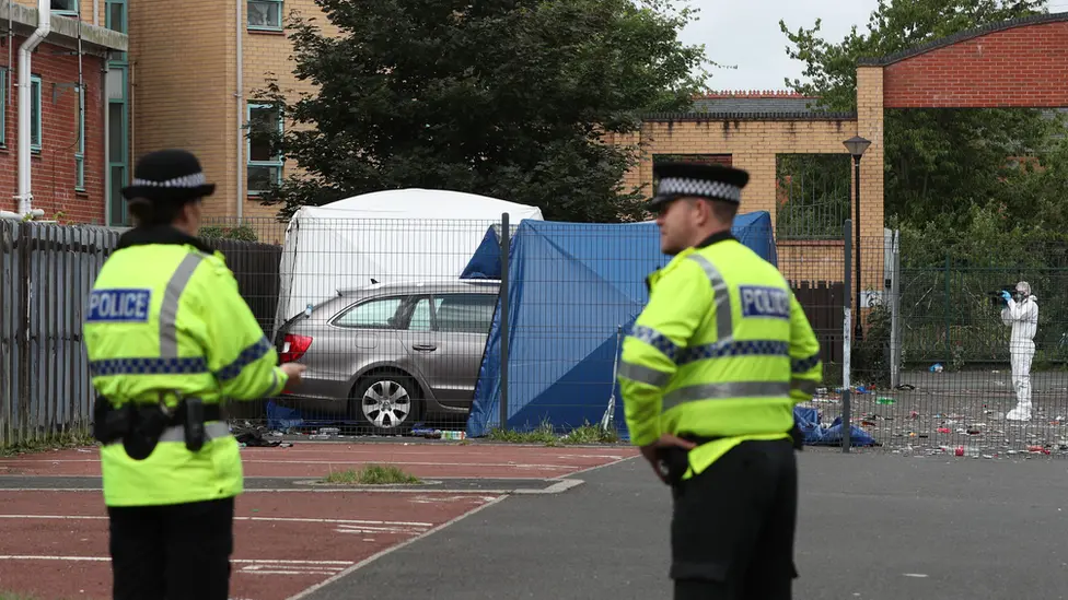 PA Media Police outside a white tent at the shooting location