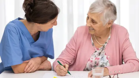 Getty Images Caregiver with elderly woman