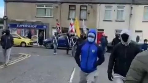 Twitter Men wearing masks parade in Portadown on 5 April